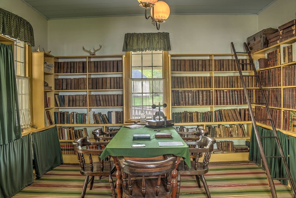 Book-lined library with a green-topped table inside Liberty Hall at A.H. Stephens State Park
