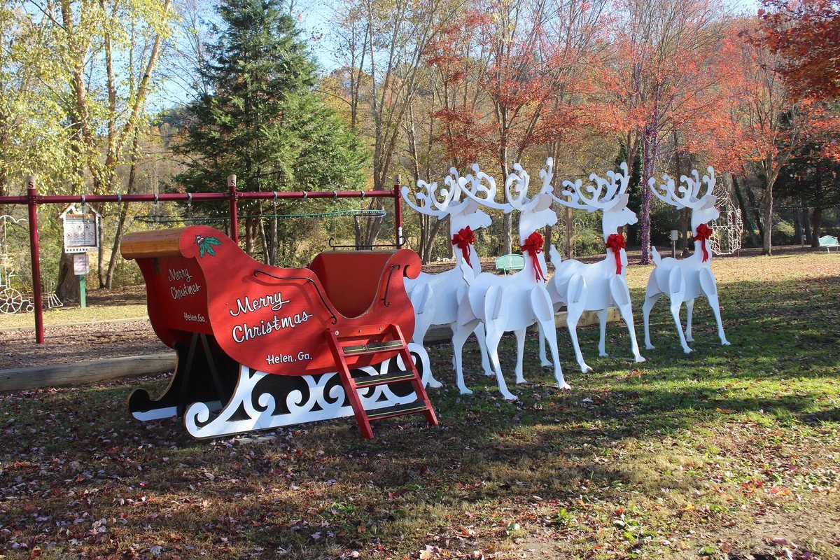 A red sleigh and white light-up reindeer decorations in Riverside Park in Helen, Georgia
