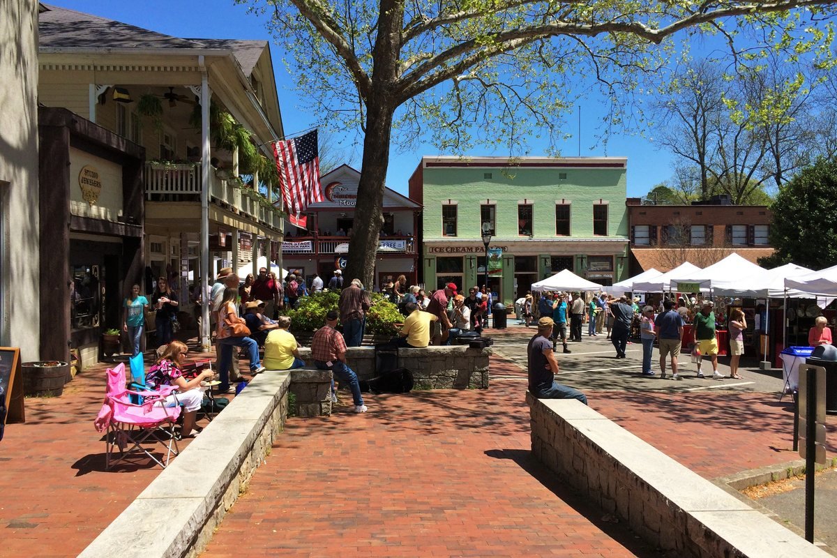 People strolling the brick sidewalks and shops of the public square in downtown Dahlonega on a sunny day