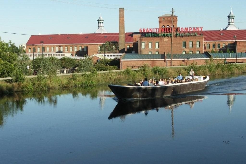 A Petersburg tour boat on the Augusta Canal in front of the brick Enterprise Mill