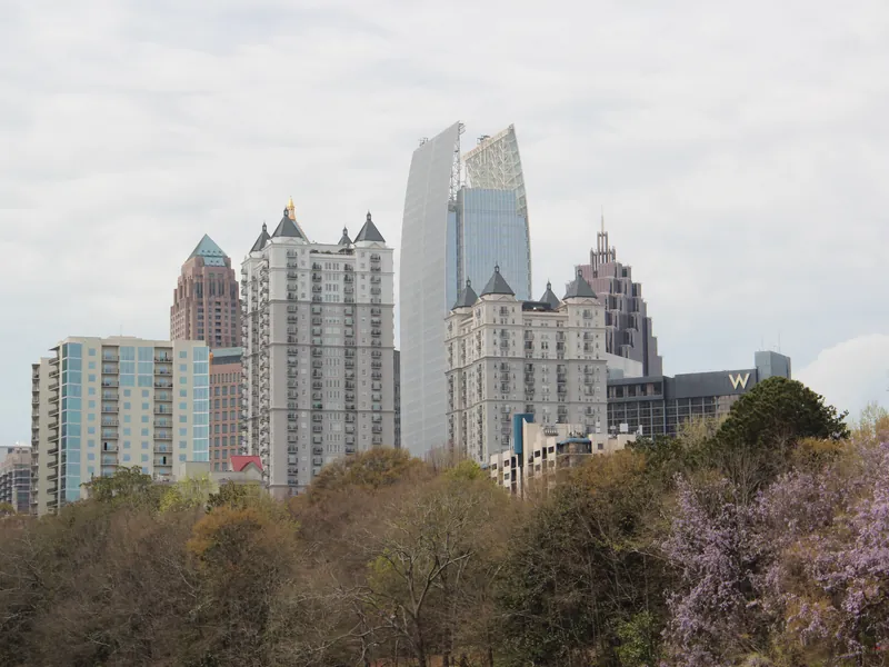Midtown Atlanta skyline rising above Lake Clara Meer and the trees of Piedmont Park