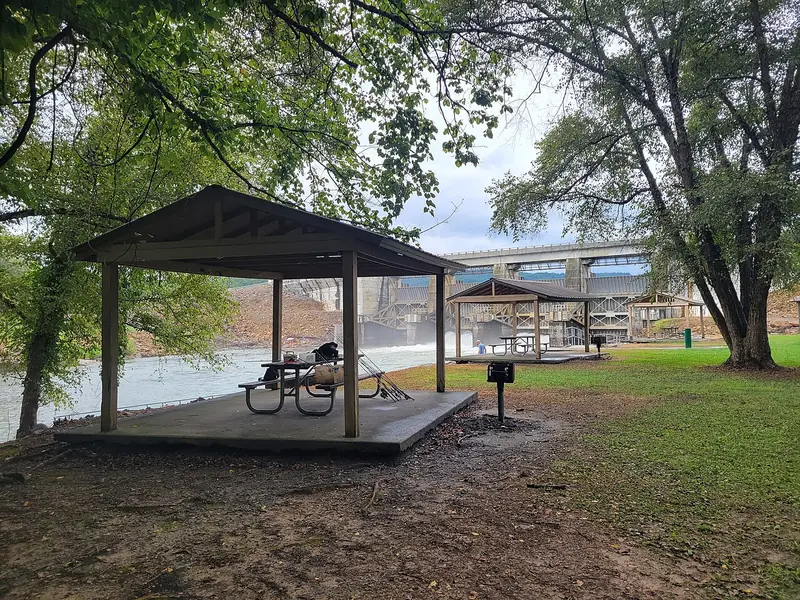 Covered picnic shelters beside the water at the Reregulation Dam Recreation Area in Murray County