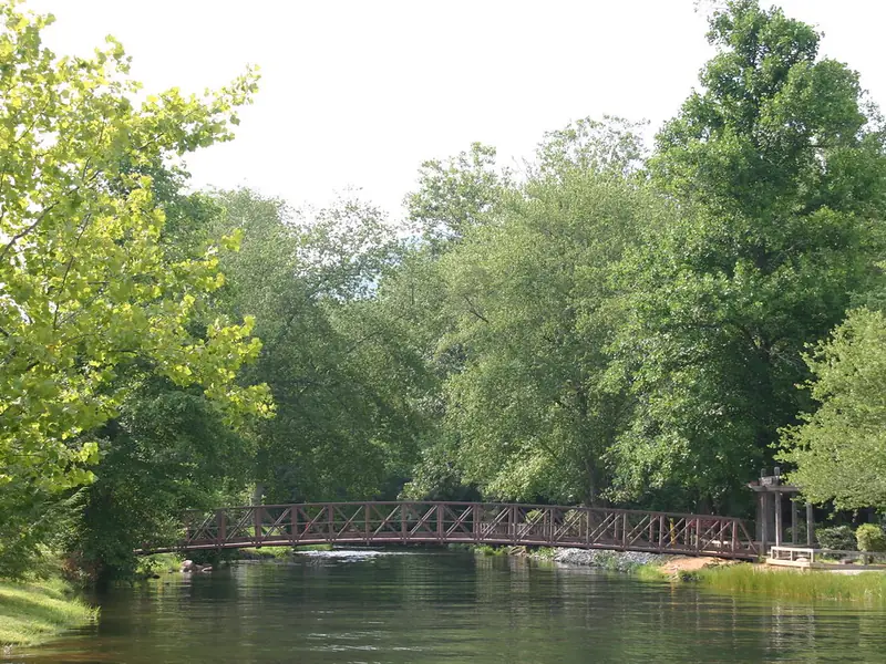 Wooden footbridge over the water among green trees at Moccasin Creek State Park