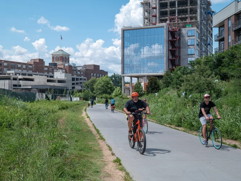 Cyclists riding the paved BeltLine Eastside Trail past new buildings in Old Fourth Ward