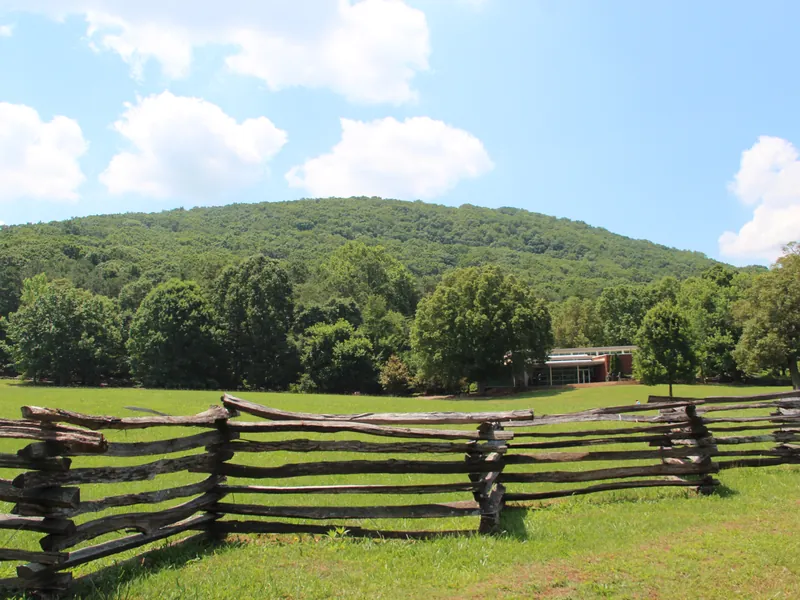 Kennesaw Mountain rising above a split-rail fence and a green field