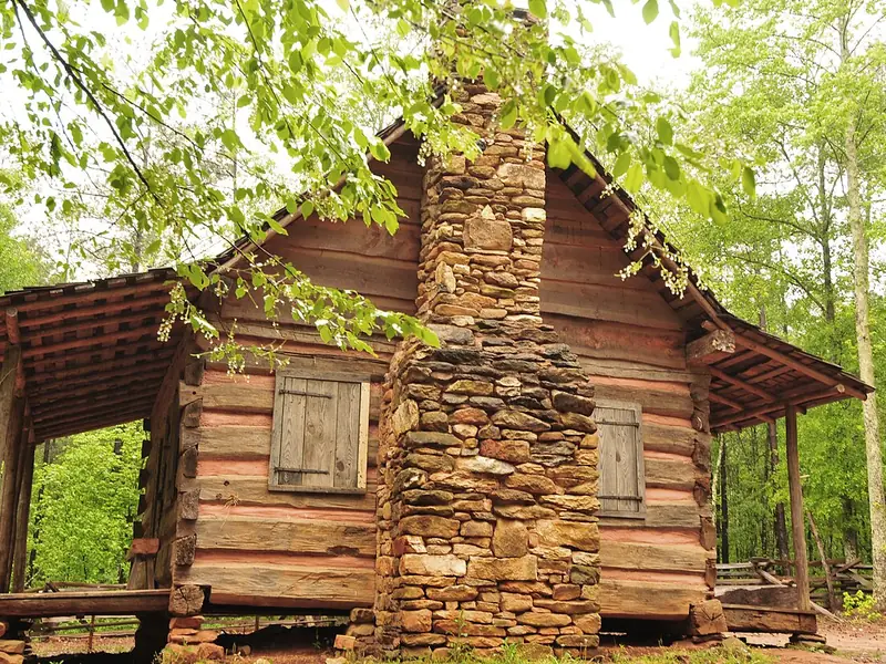 Log pioneer cabin with a stone chimney at Pickett&rsquo;s Mill