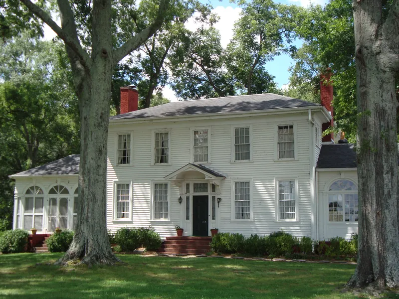 The white two-story Chieftains Museum, home of Cherokee leader Major Ridge, among oak trees