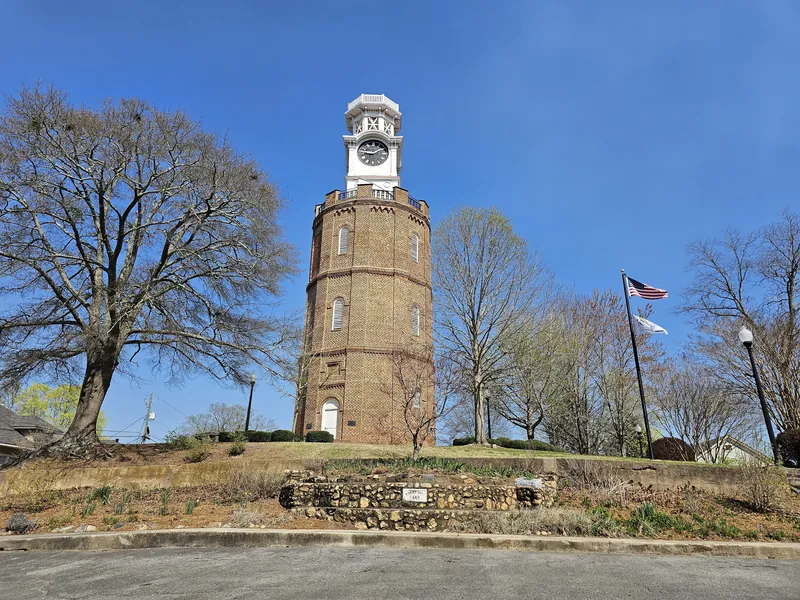 The ten-sided brick Clocktower on top of a hill in Rome, Georgia, under a blue sky