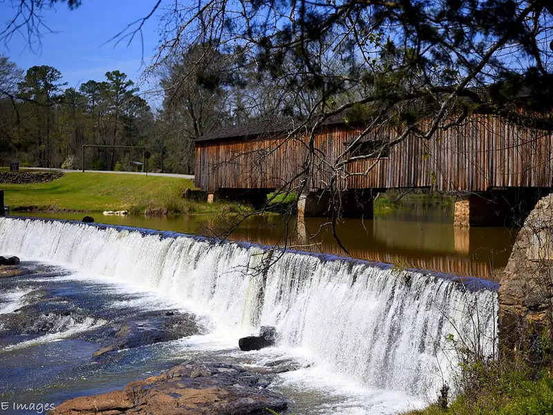Water pouring over the spillway below the Watson Mill covered bridge