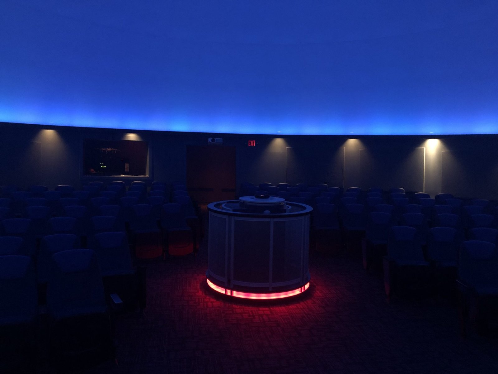 Inside the Mark Smith Planetarium: rows of seats under a blue-lit dome around a central projector