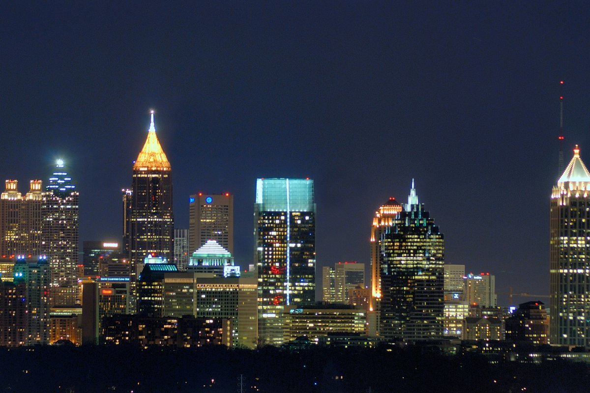 The downtown and Midtown Atlanta skyline lit up at night, seen from Buckhead