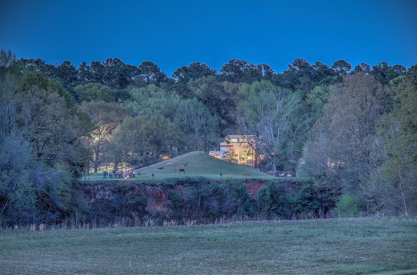 The grass-covered Earth Lodge mound and the park visitor center seen from the top of the Great Temple Mound