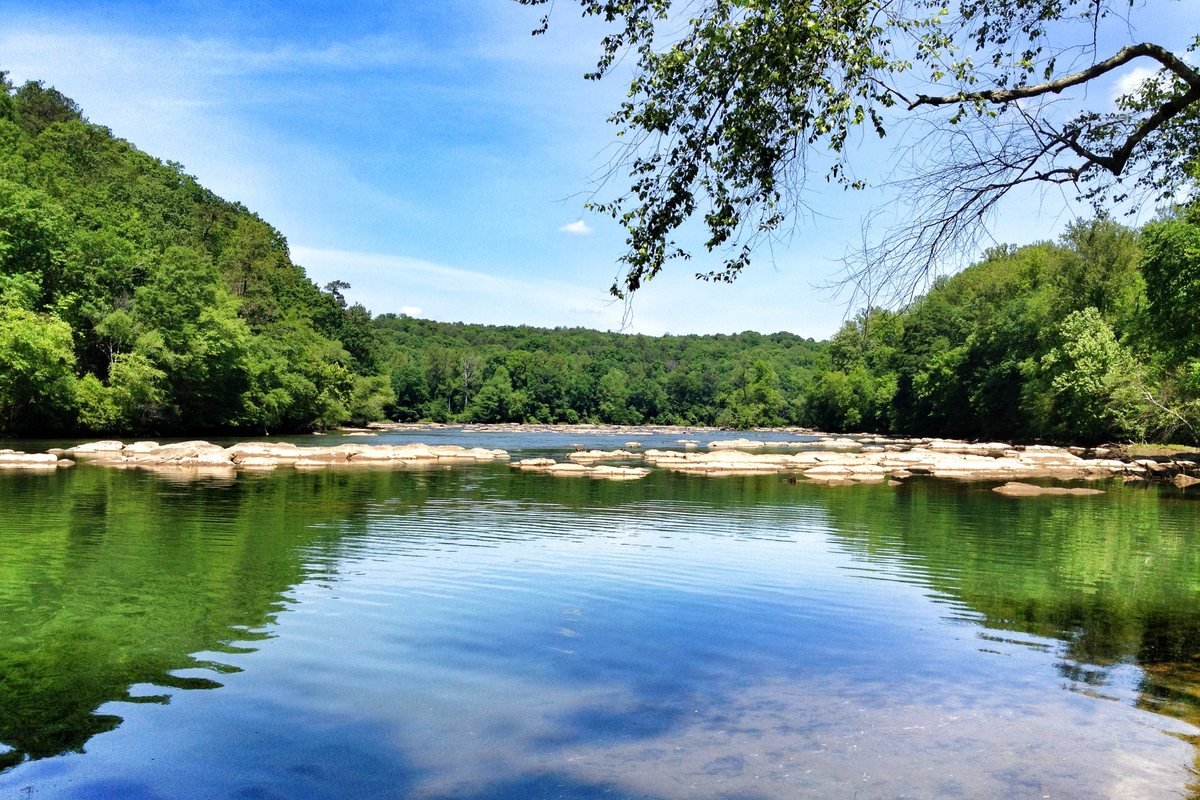 The Chattahoochee River flowing past wooded bluffs and rocks at East Palisades in Atlanta