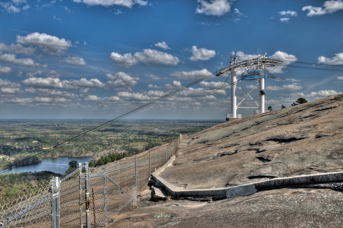 A Summit Skyride tower on the granite top of Stone Mountain with the lake and forest far below